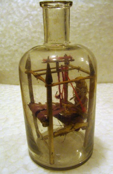 Översiktsbild av flaska med vävstol och docka