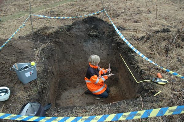 En person sitter på hus i en stor utgrävning