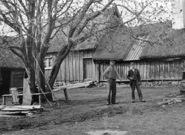 Två personer som står framför ett gammalt hus