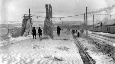 Tre personer som går längs en snöig väg