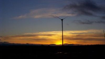 Foto av en vindkraftsverk i solnedgången