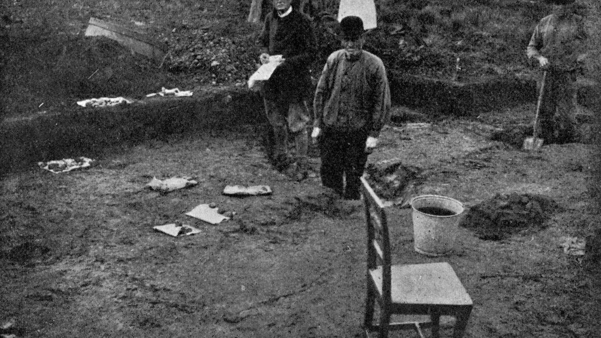 Undersökning från 1918. Flera personer arbetar i grävandet. En stol står vid kanten.