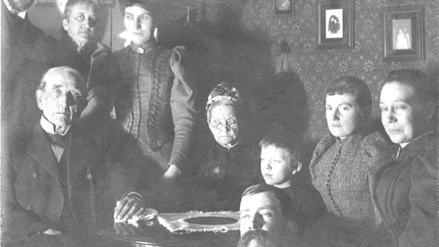 Svartvitt foto med familjekonstellatin bestående av åtta personer.