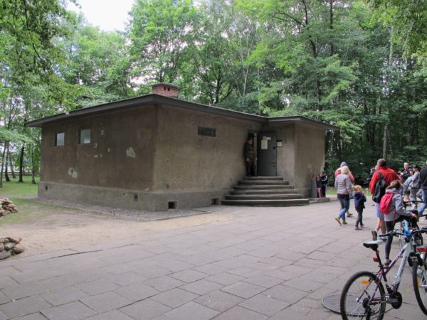 Ett rekonstruerat vakthus med turister omkring.