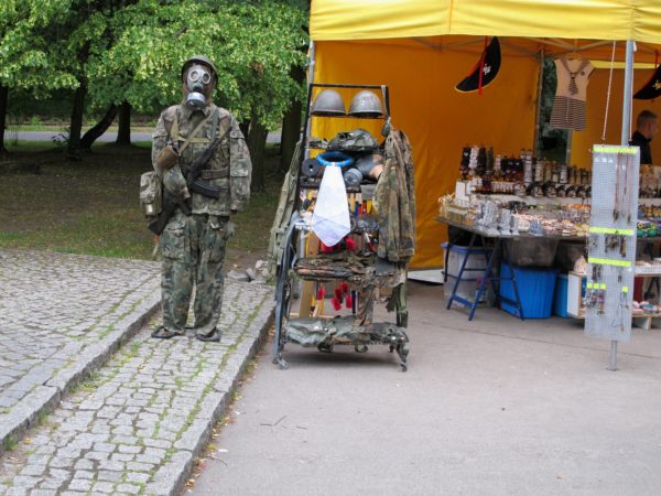 Ett stånd som säljer souvenirer. Till vänster är en docka uppsatt med militärkläder, hjälm och gasmask.