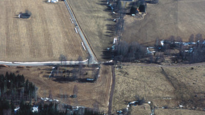 Flygfoto från Edshult med säteribyggnaden i bakgrunden, kyrkoplatsen till vänster och borgruinen i förgrunden.