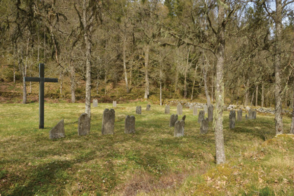 Tovig ängsmark med handhuggna gravstenar från 1700-talet.