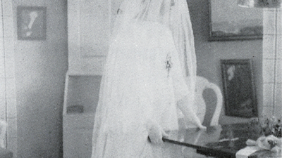 En kvinna med vit klänning och vit slöja.