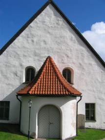 En vit kyrka med rött tegeltak.