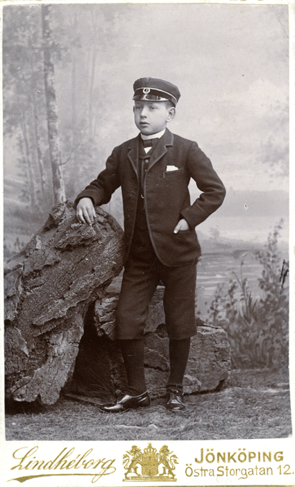 En ung kille med keps och kostym.