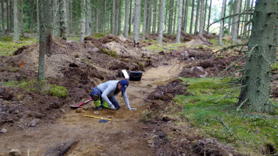 En arkeolog gräver i skogen