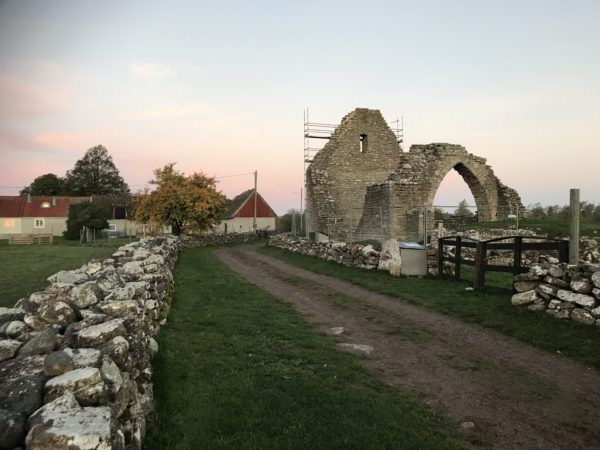Ruin av en stenbyggnad, en grusväg och en stenmur