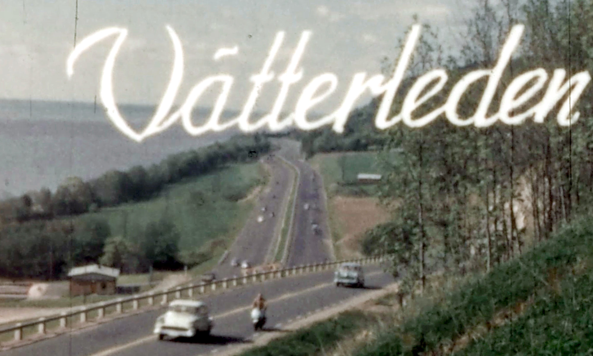 En stillbild ur en äldre film, med vy över en motorled genom ett grönskande landskap. I bilden står titeln Vätterleden