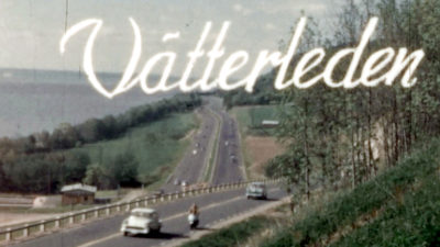 En stillbild ur en äldre film, med vy över en motorled genom ett grönskande landskap. I bilden står titeln Vätterleden