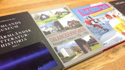 Fyra årsböcker från några länsmuseer ligger bredvid varandra på ett bord.
