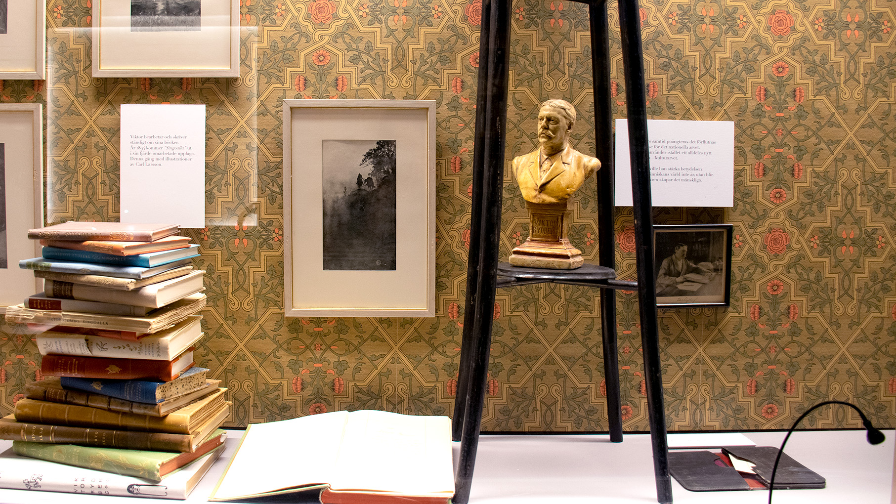 Foton och en statyett av Viktor Rydberg skymtar i utställningsmonter