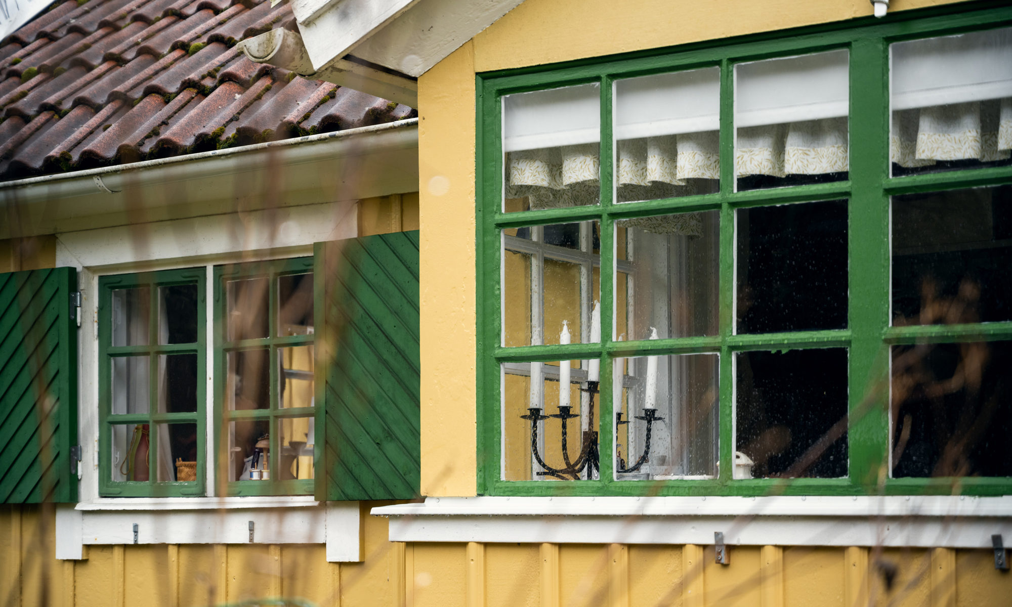 Gröna fönster mot gul fasad