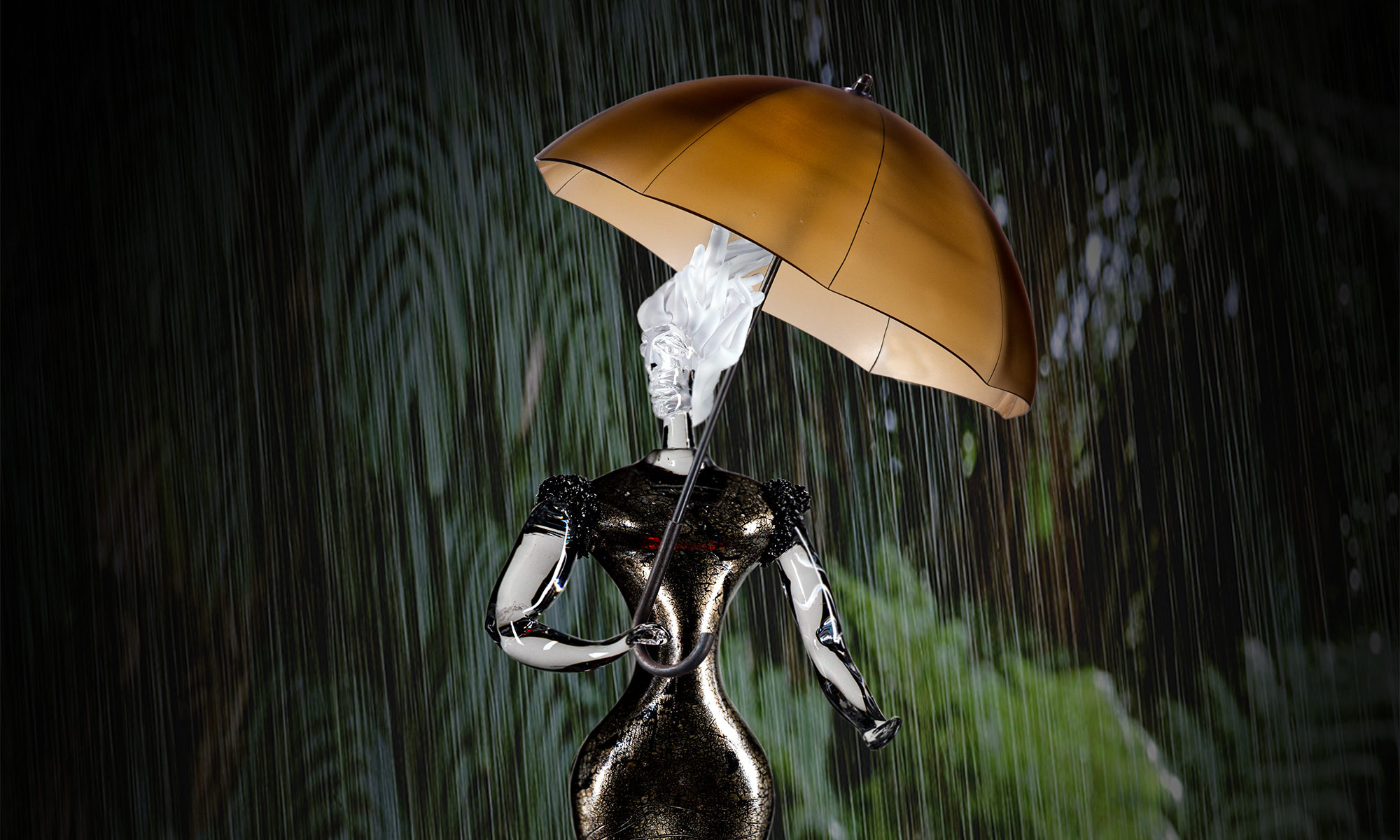 Figur i glas som håller ett uppfällt paraply med sina båda händer