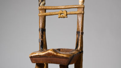 En stol med säregen utformning och målningar på stolsben och stolsrygg