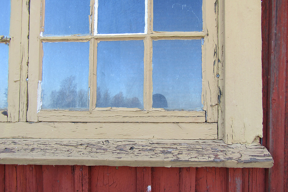 Detalj av spröjs på ett äldre fönster i behov av renovering