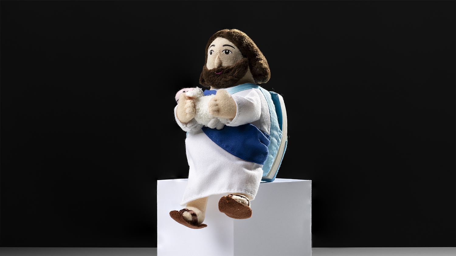 En liten textil figur av Jesus som håller i ett lamm
