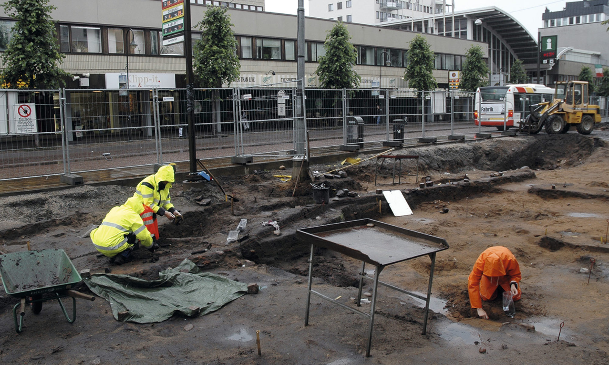 Tre arkeologer i varselkläder vid en arkeologisk utgrävning i centrala Jönköping