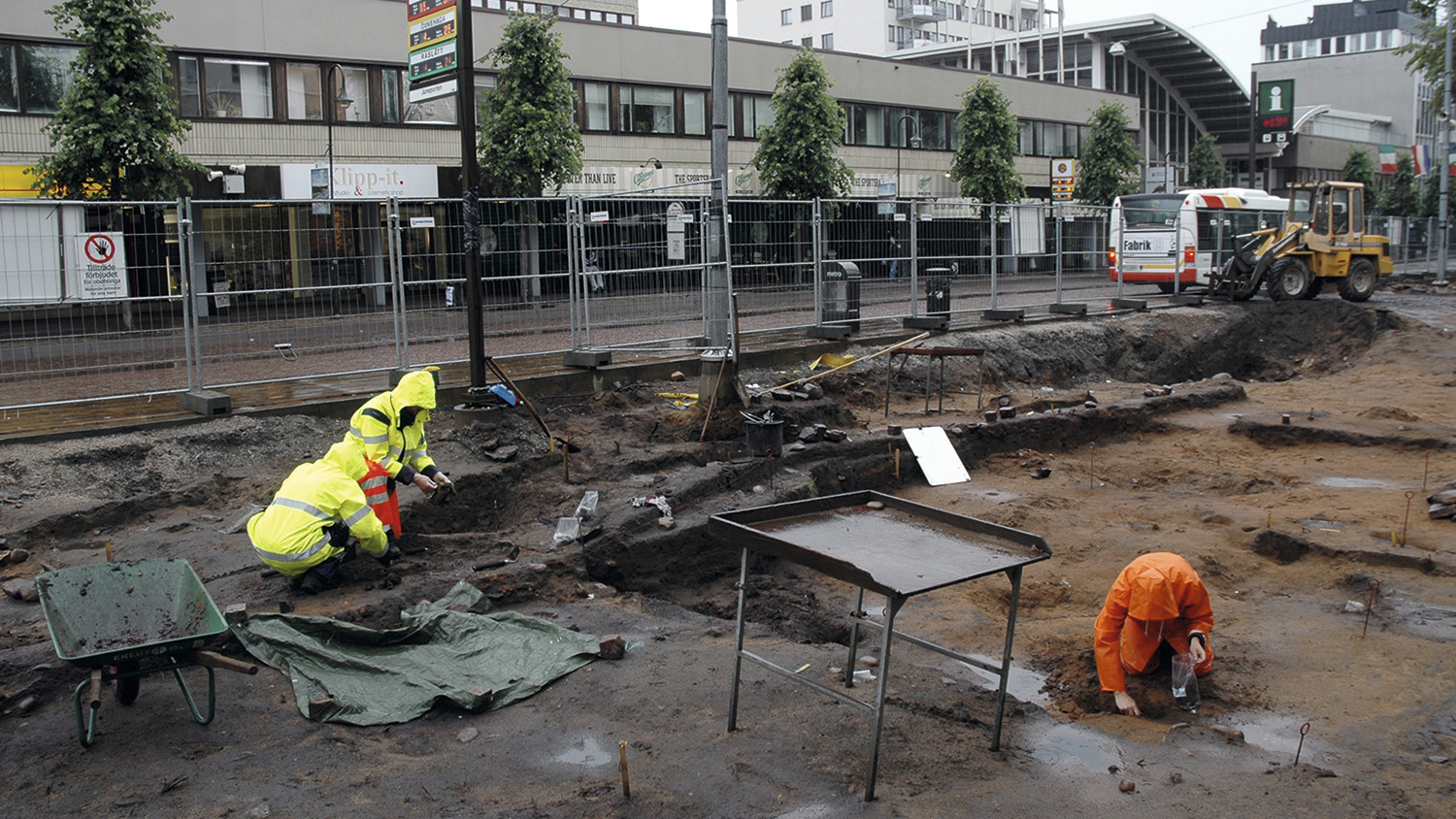 Tre arkeologer i varselkläder vid en arkeologisk utgrävning i centrala Jönköping