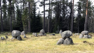 Ett gravfält med stora stenar staplade på varandra i flera högar