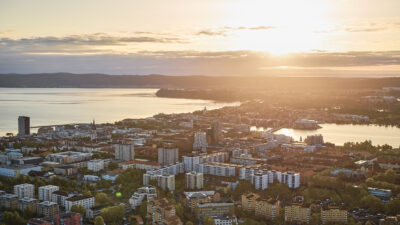 Morgonljus över en stad, där man ser två sjöar