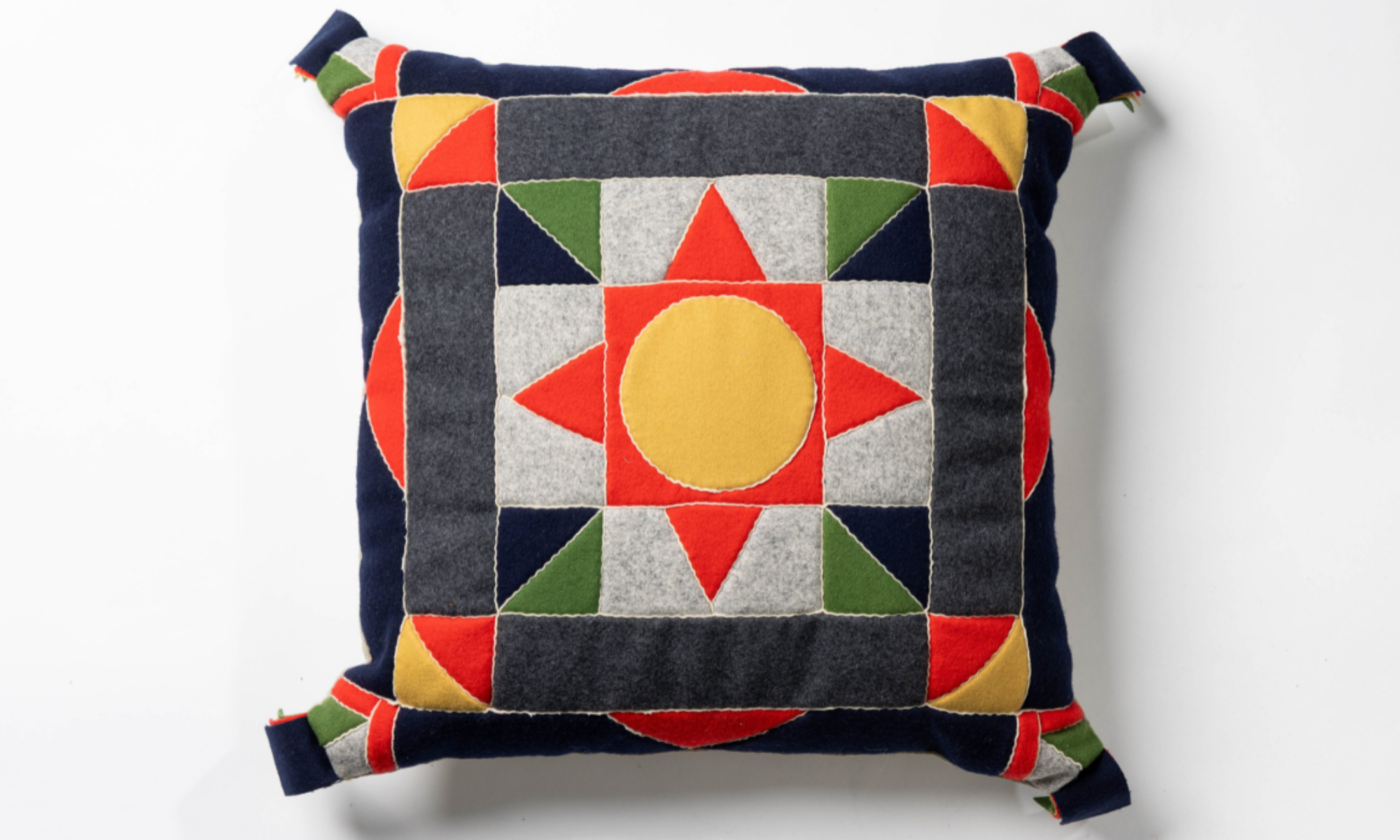 En färgglad kudde sydd med tekniken skarvsöm.
