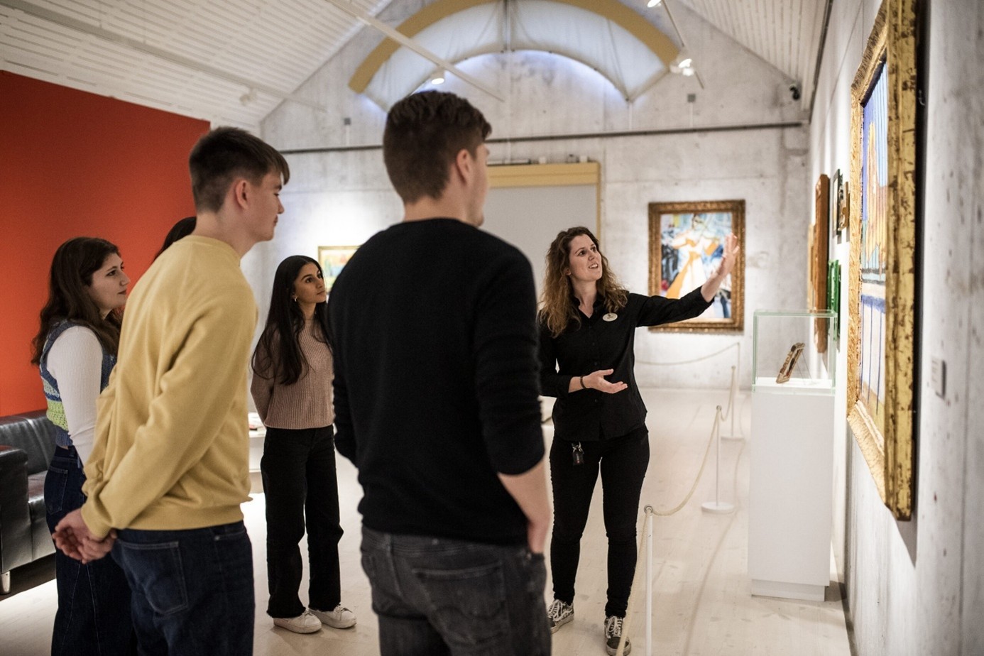 En museivärd visar en grupp ungdomar en tavla.